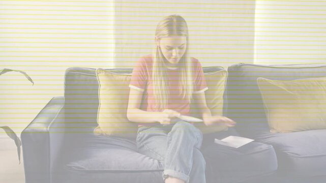 Woman opening mail on couch, sorting papers and reading, reviewing finances, scan lines overlaying