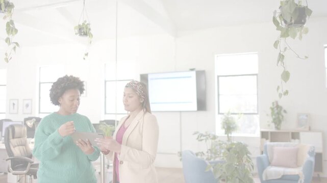 Two colleagues pointing and tapping tablet, starting animated chart on monitor for business review