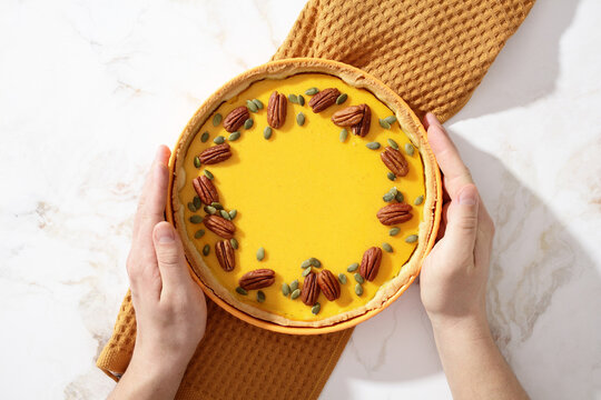 Homemade American pumpkin pie with pecans on marble