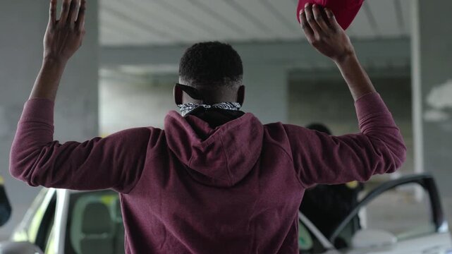 Shot back african american offender in mask stand hands up in patrol car in handcuffs burglar crime hold danger gangster gun robber handgun illegal law outlaw arrest bad guy close up slow motion