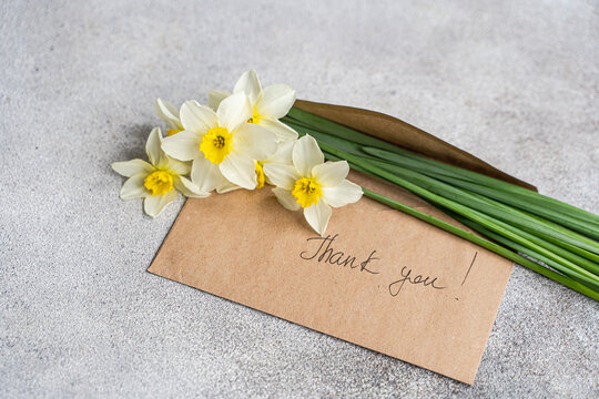 Spring daffodil bouquet with thank you note on stone