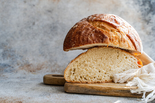 Rustic sourdough bread loaf sliced on wooden board