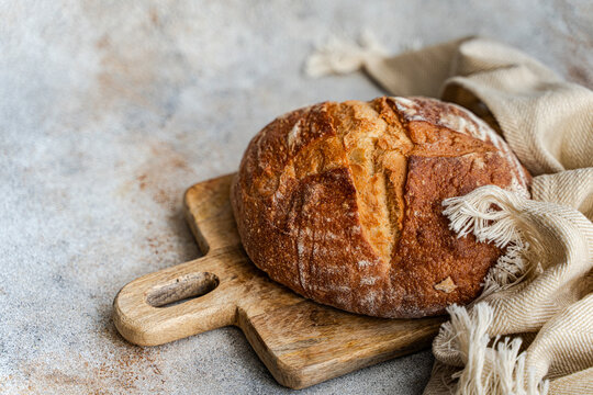 Rustic sourdough bread loaf on wooden board, copy space
