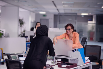 Fototapeta premium Middle Eastern colleagues having a friendly conversation at a modern open office during a business meeting