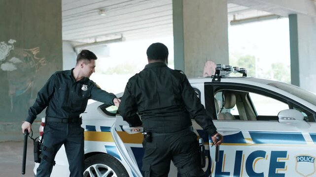 Young policemen are standing near the car with a african american robber dance together run in handcuffs arrest bad guy crime dangerous gun illegal law pistol security emergency slow motion