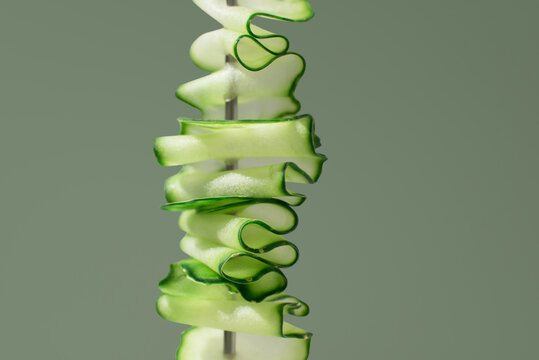 Fresh sliced cucumber ribbons stacked on skewer, close up