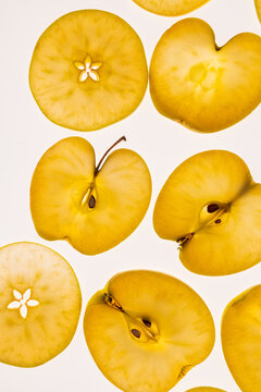 Golden apple slices on light background, flat lay pattern