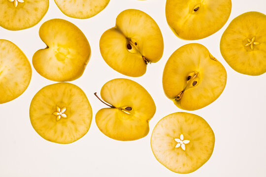 Yellow apple slices pattern on white background, top view