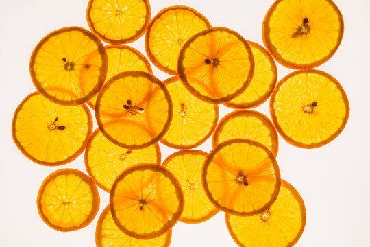 Backlit orange slices pattern on clean white background