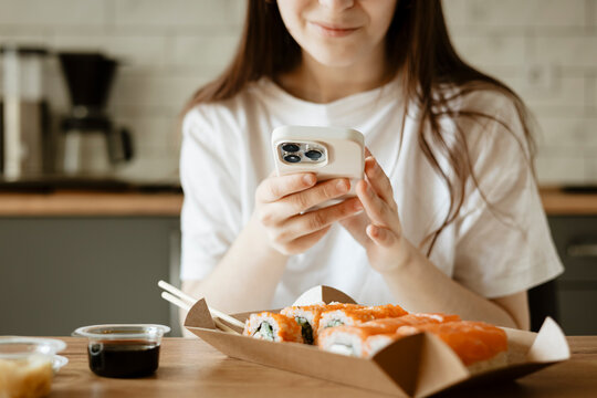 Enjoying sushi on a day off at home with smartphone