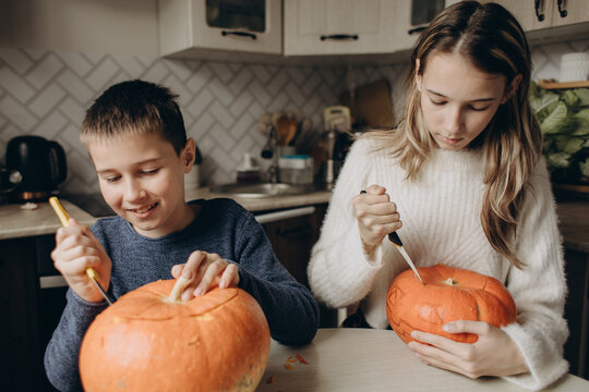 Children carving pumpkins at home for Halloween craft
