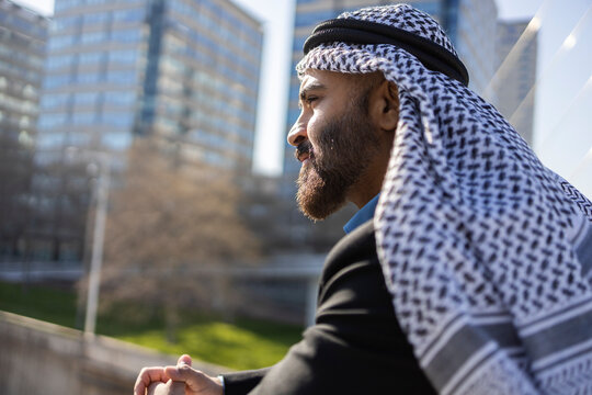 Arab businessman sheikh in keffiyeh overlooking city skyline