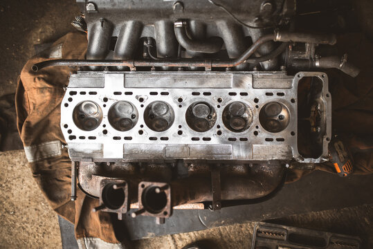 Close-up view of a disassembled internal combustion engine cylinder head and manifold