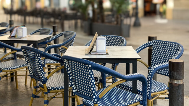 Outdoor Cafe Tables And Wicker Chairs On City Street, Cozy Restaurant Terrace With Empty Seating, Urban Lifestyle Scene, Shallow Depth Of Field And Copy Space