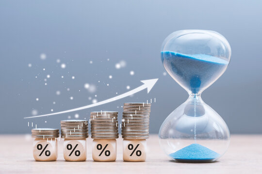 Stacked coins on percentage blocks growing over time with hourglass. Concept long term investment and compound interest. Financial growth, savings strategy, banking and fintech wealth.