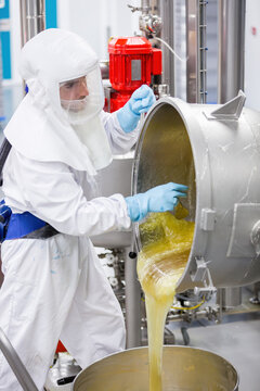 Candy technician pouring molten syrup in factory lab