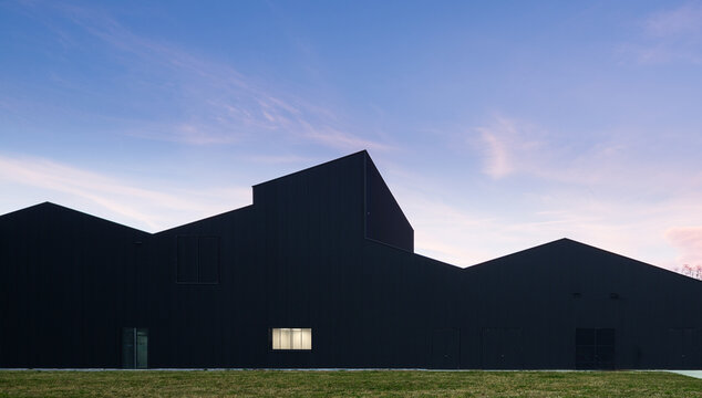 Modern candy factory warehouse silhouette at dusk sky