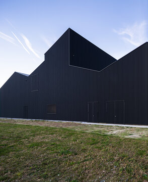 Modern black metal warehouse facade under clear sky