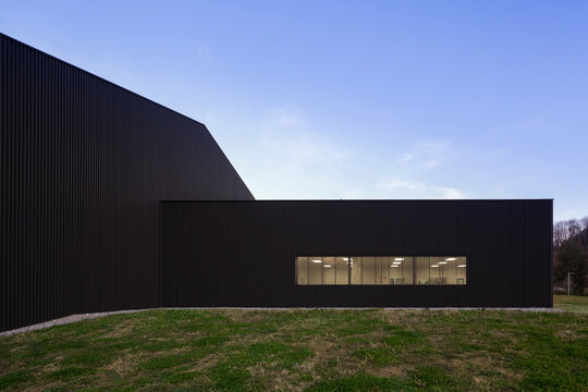 Modern candy factory exterior with black metal facade at dusk