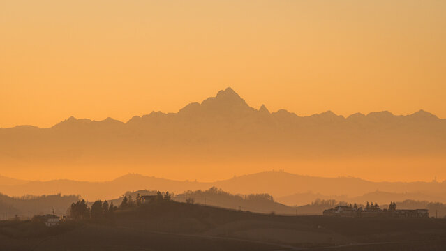 Sunset haze over layered hills and Alps in Piemonte, Italy