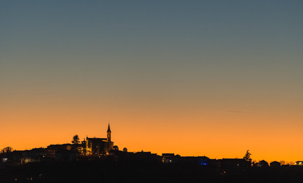 Sunset silhouette of a hill village in Piemonte, Italy