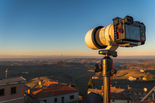 Photographer camera on tripod at sunset in Piemonte, Italy