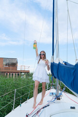 Fototapeta premium A joyful woman is celebrating by the peaceful water, holding vibrant flowers and enjoying the beautiful view around her