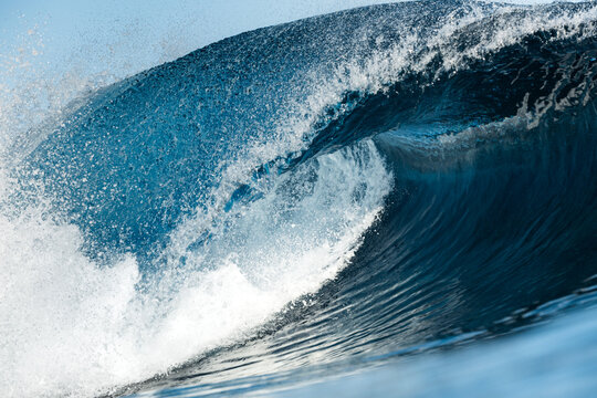 Powerful ocean wave curling with spray and blue water