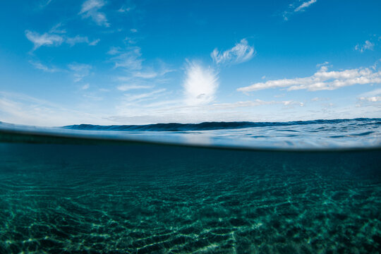 Split-level view of calm ocean surface and clear water