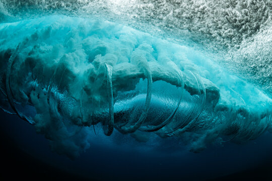 Underwater view of powerful ocean wave curling with bubbles