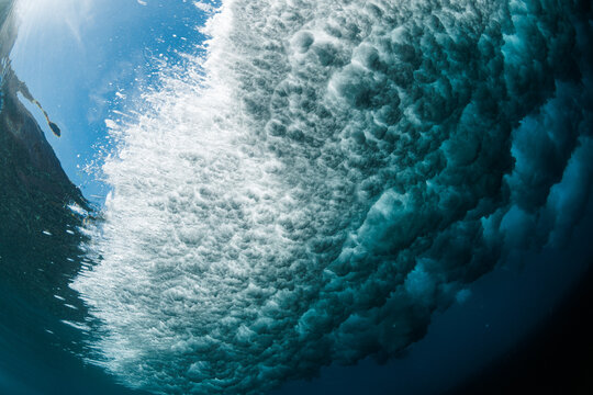 Underwater view of a breaking wave with frothy bubbles