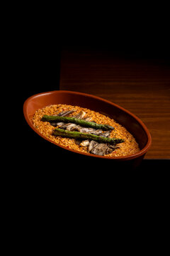 Spanish rice in terracotta dish on wooden table