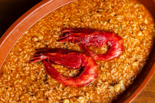 Spanish rice stew with prawns served in a clay dish