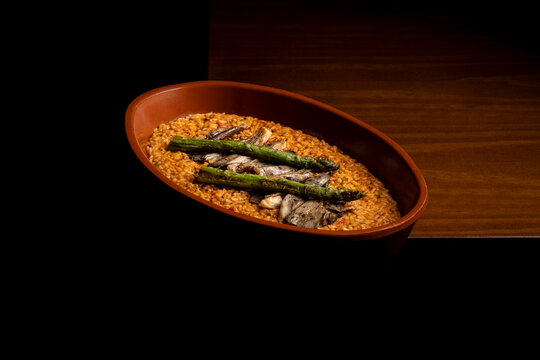 Spanish rice in terracotta dish on wooden table