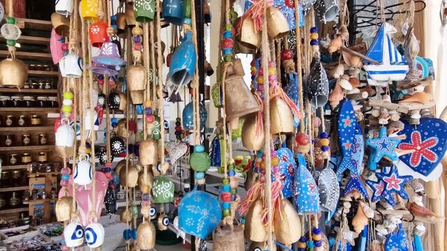 Authentic hand painted Greek goat bells and wooden marine decor in Spili, Crete. Close up of traditional colorful bells and nautical handicrafts in local shop. Mediterranean art Greece