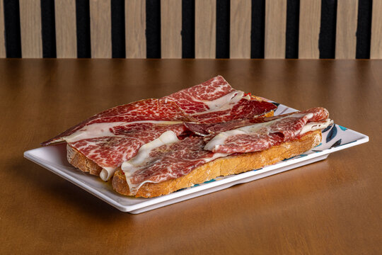 Traditional breakfast toast topped with cured ham slices