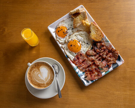 Classic breakfast with eggs, bacon, toast, coffee and juice