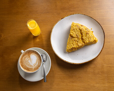 Morning breakfast with omelet slice, latte, and juice
