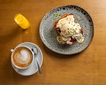 Gourmet breakfast plate with latte art and orange juice