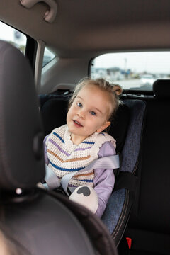 Toddler in car seat buckled safely during family drive