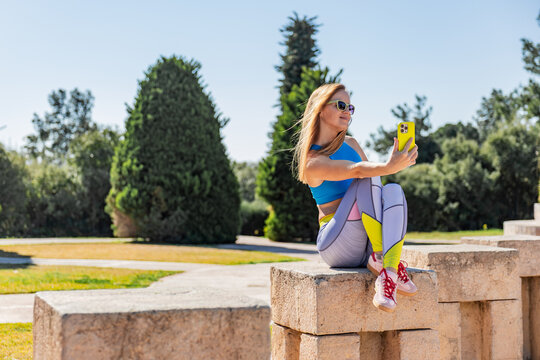 Woman taking selfie in sunny park setting