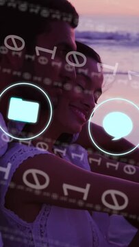 Vertical video: Couple sitting on shore while bits and apps fading, revealing romantic bond in tech