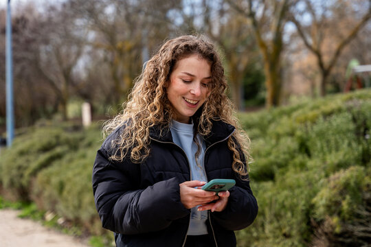 Young woman enjoying outdoors with smartphone