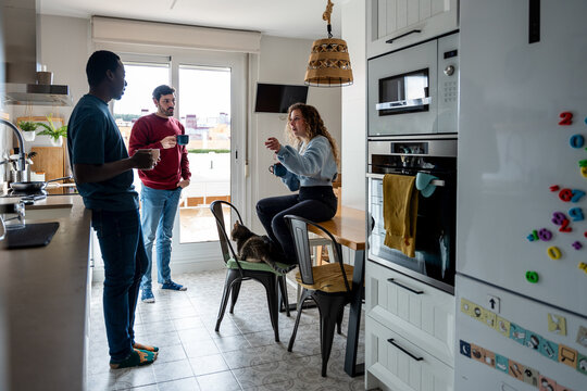 Friends enjoying coffee and laughter in the kitchen