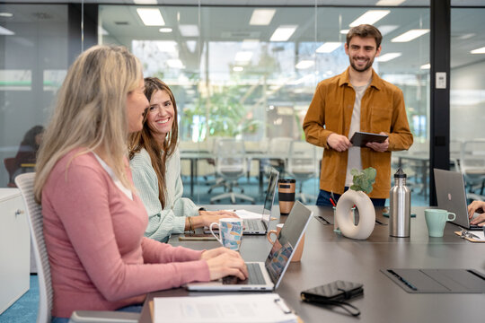 Coworking team meeting around laptop in modern office