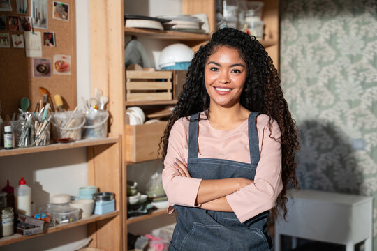 Smiling potter in apron at pottery workshop studio