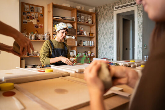 Potter shaping clay during a pottery workshop in studio