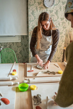 Young woman shaping clay slab in pottery workshop studio