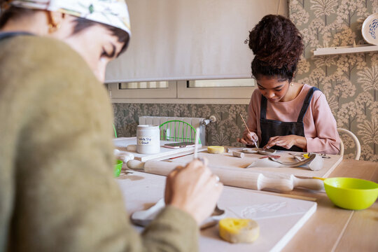 Woman crafting ceramic piece in pottery workshop at table