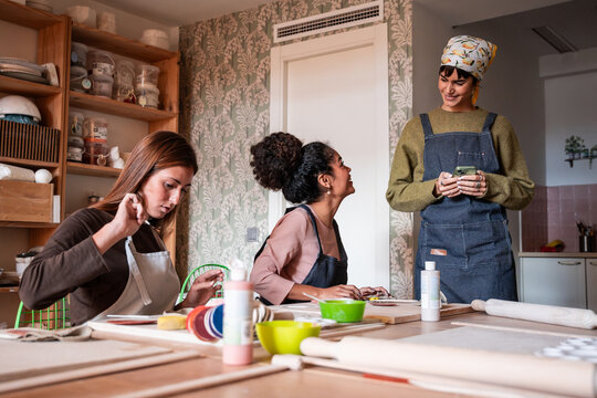 Pottery workshop class with women shaping clay and chatting